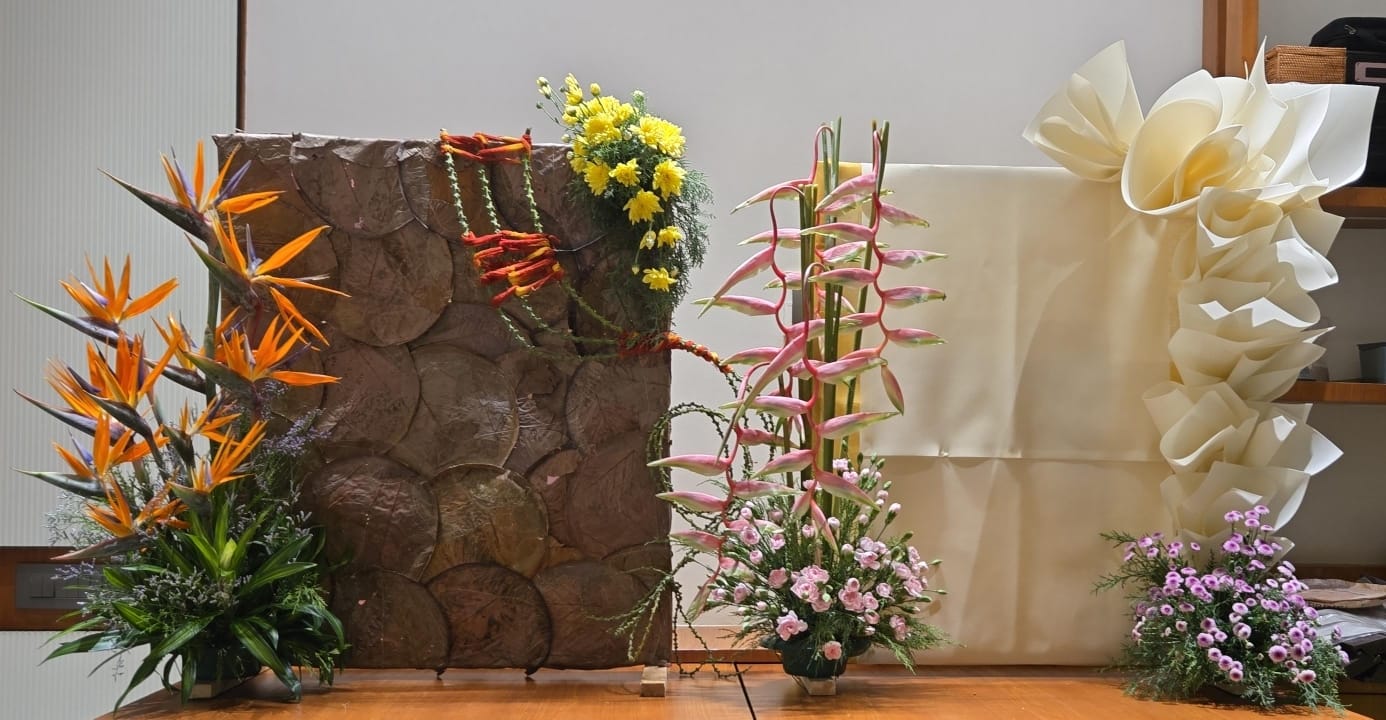 Pink heliconia and hand-folded cream paper forms in a festive setting